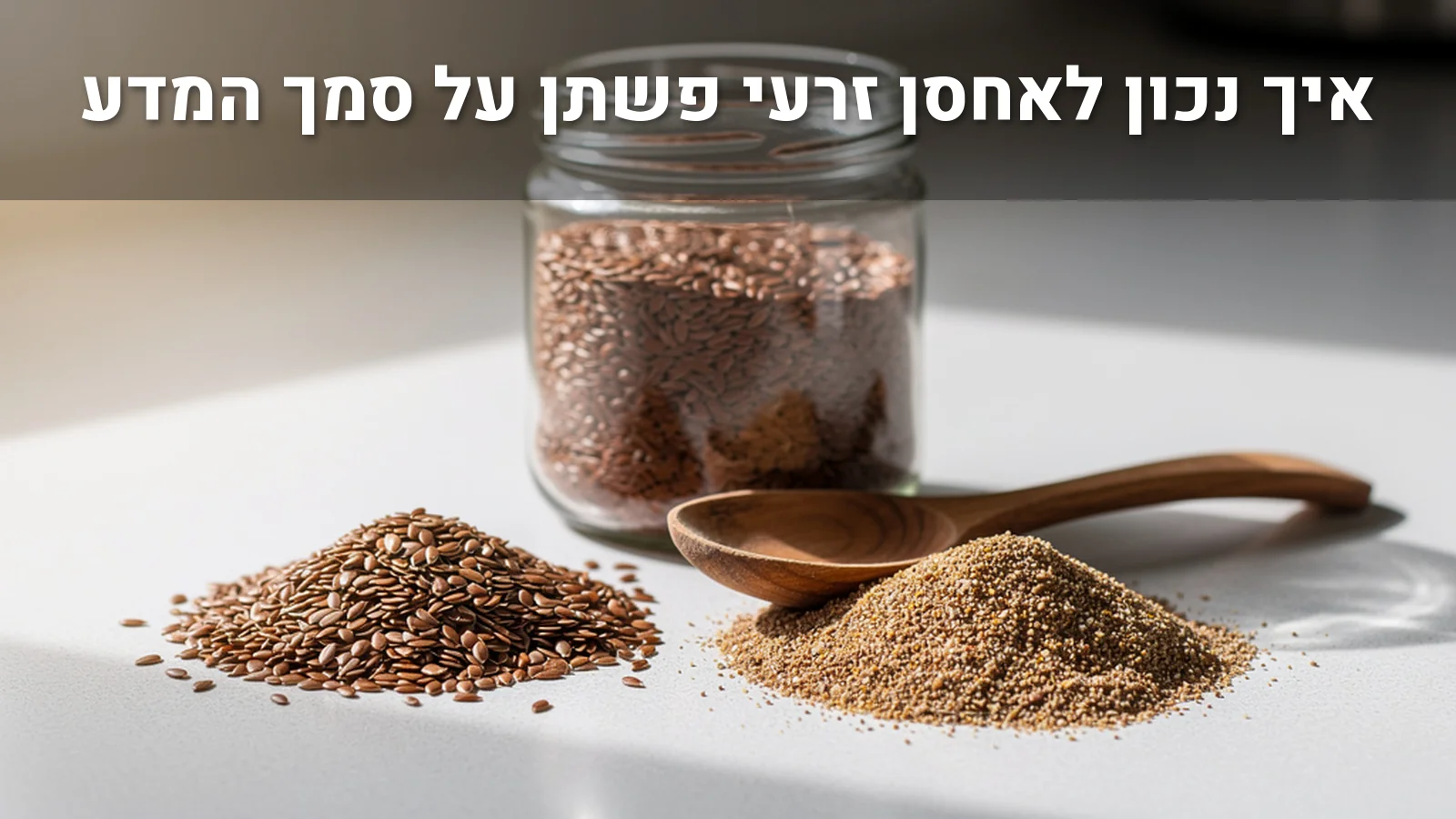 זרעי פשתן שלמים וטחונים, צנצנת זכוכית וכף עץ על משטח מטבח בהיר